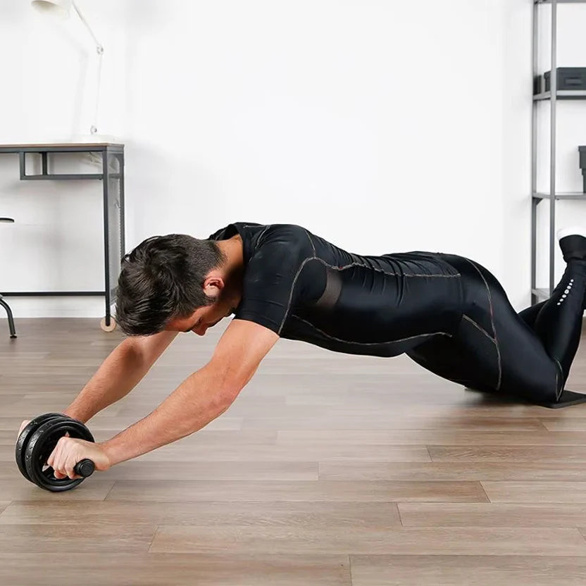 Man performing push-ups with an ab wheel in a home office setting